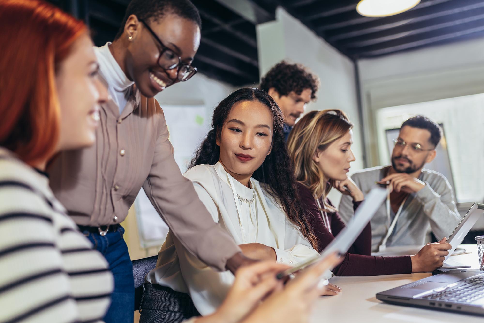 Un groupe de professionnels collaborant au cours d'une réunion, illustrant les programmes d'apprentissage linguistique de Rosetta Stone pour les entreprises afin d'améliorer la communication et le partage des connaissances au travail.