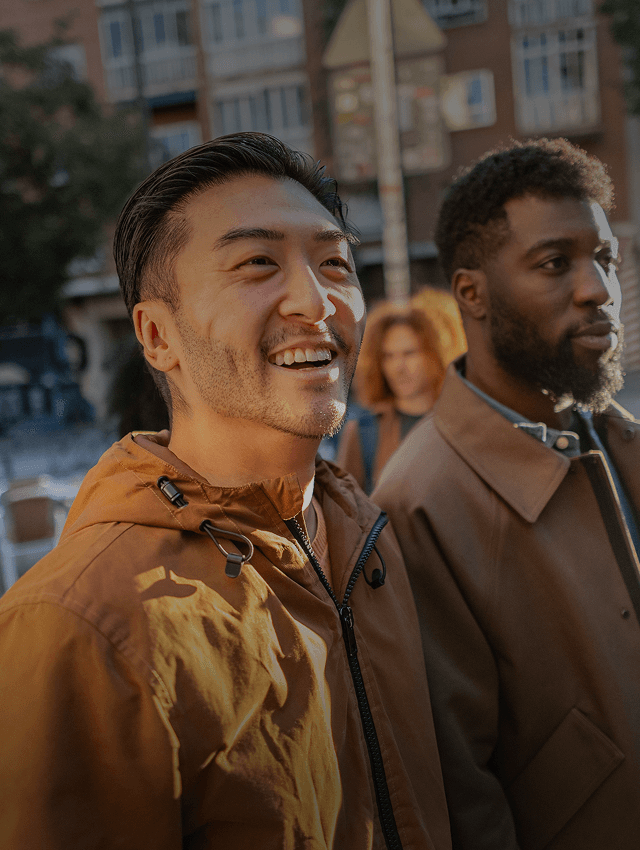 Des amis souriants marchent dans une rue d'un nouveau pays.