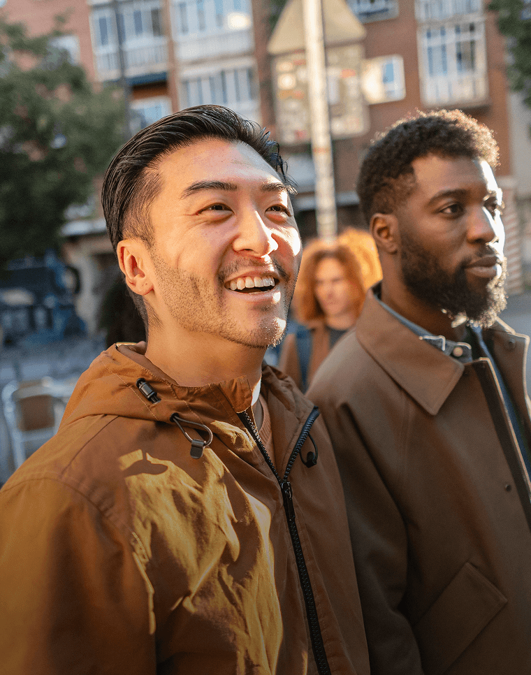 Des amis souriants marchent dans une rue d'un nouveau pays.